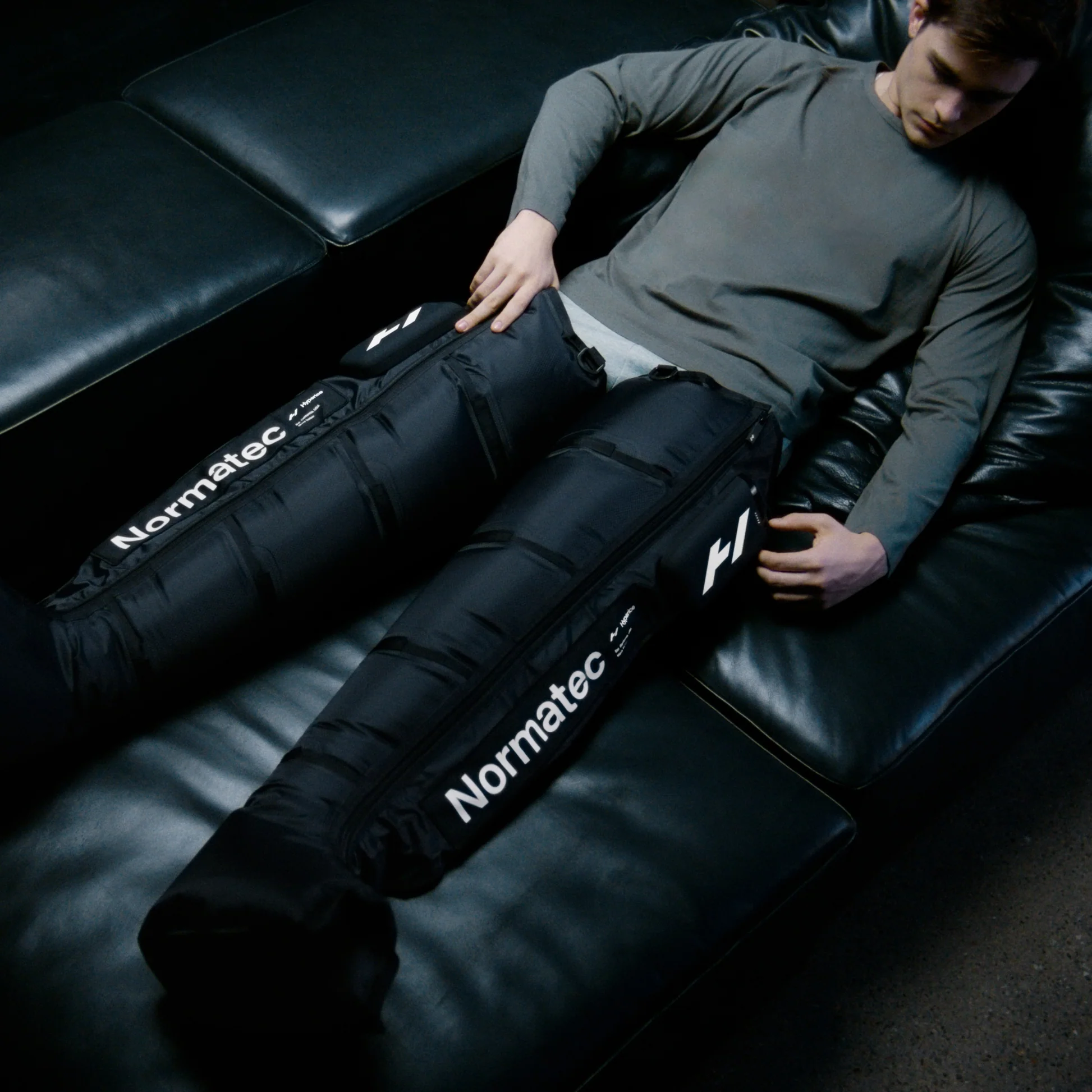 Athlete using Normatec Elite compression boots for leg recovery